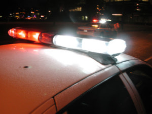 Close up photo of police car lights flashing white and red